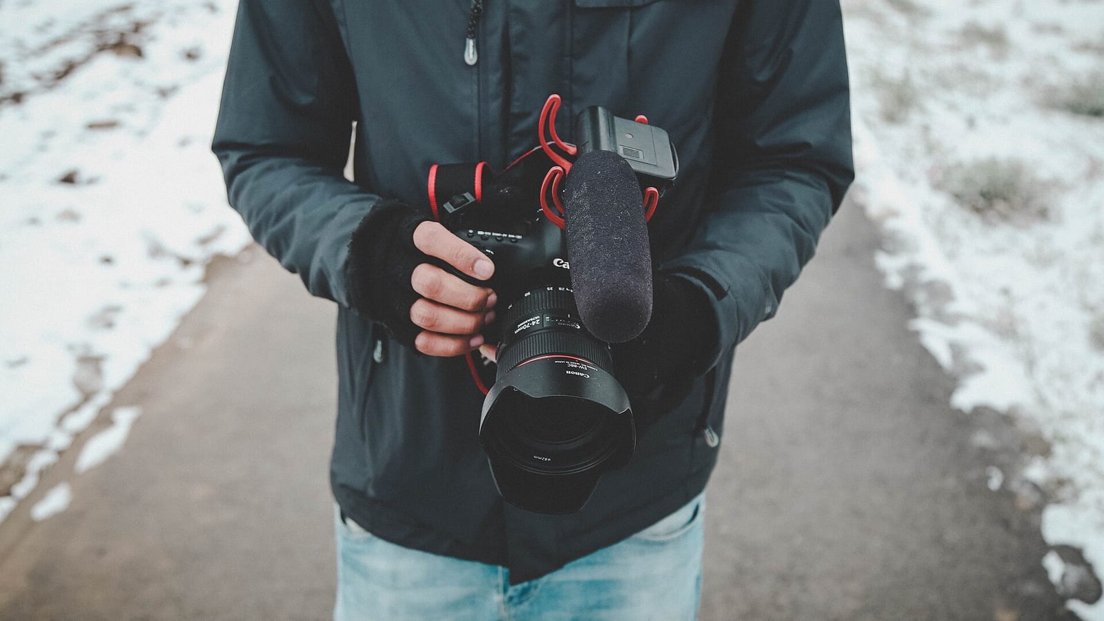 A camera operator recording with a Canon camera.